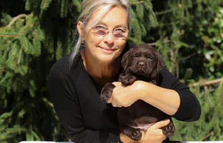 02 donna felice abbraccia labrador chocolate cucciolo